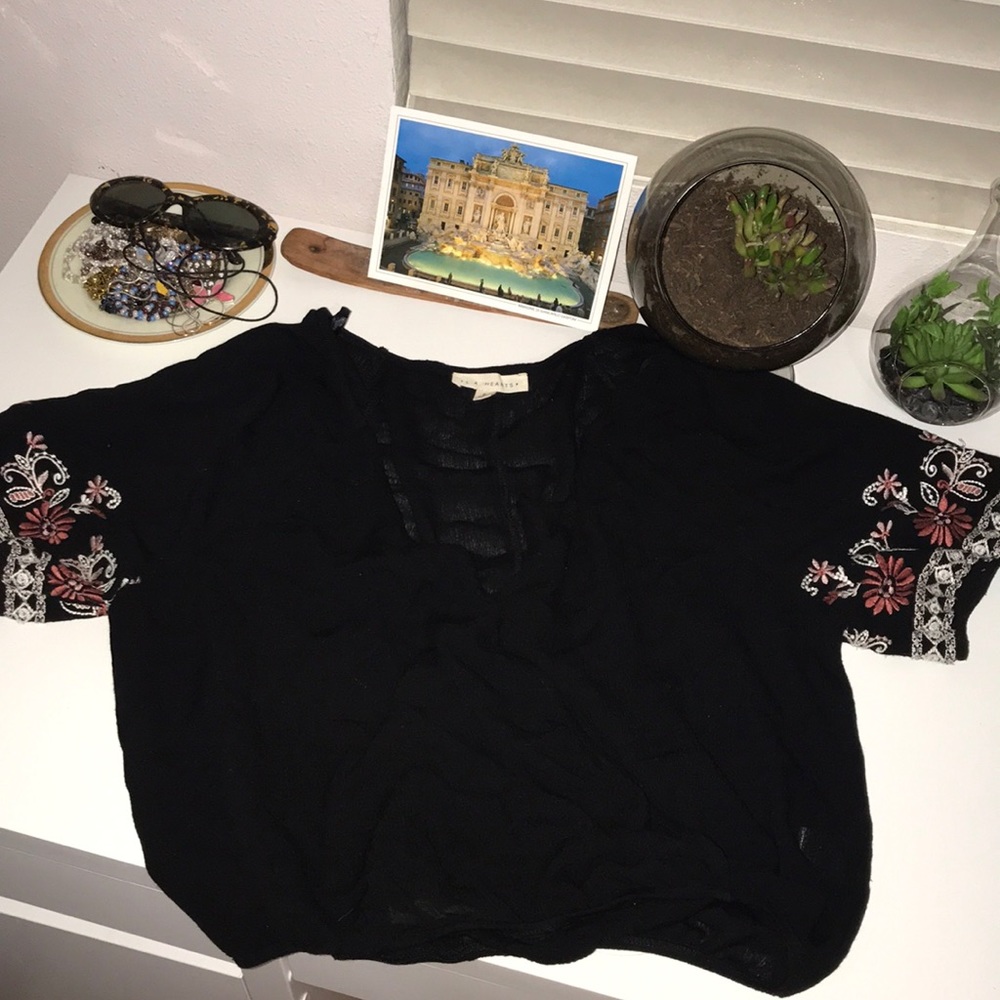 Black loose crop with floral print on the sleeves.